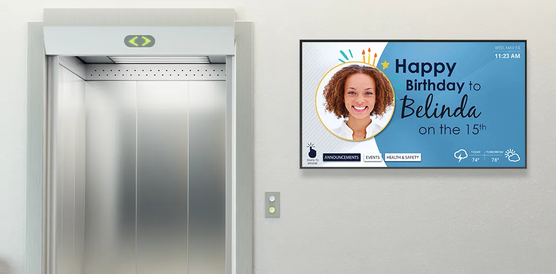 photo of elevator door with large digital sign showing employee announcements