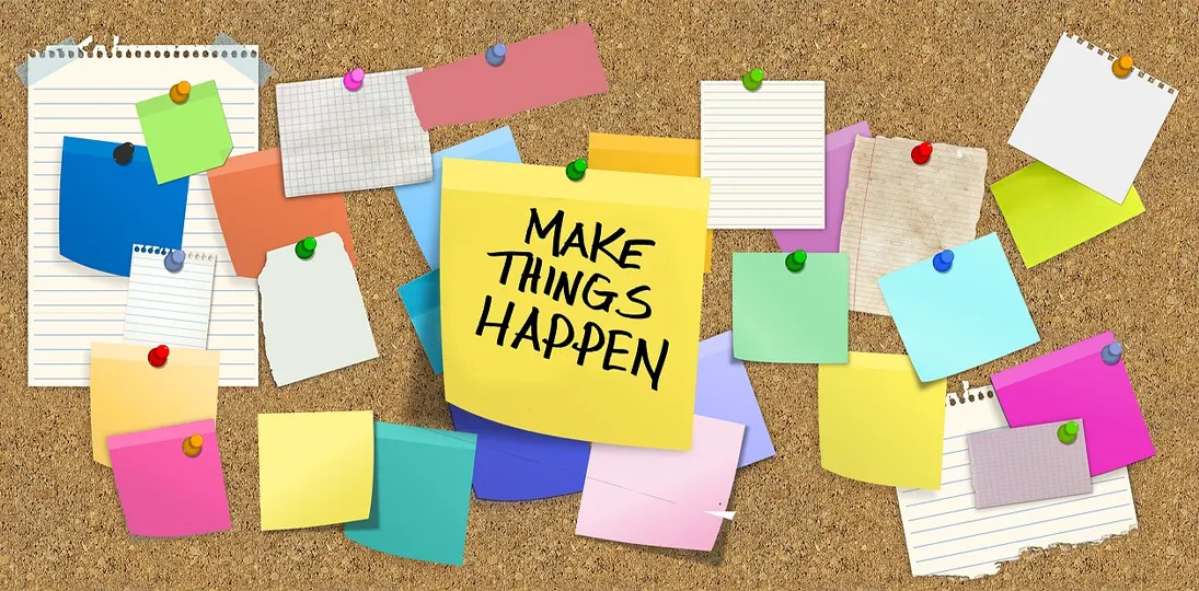 HR cork bulletin board with colorful sticky notes and a central note that says "make things happen" to represent human resources goals