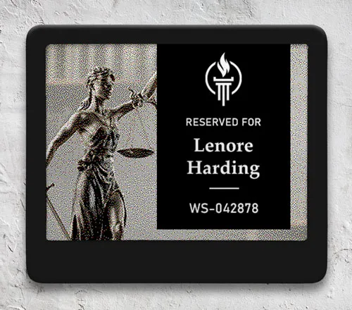 ePaper desk sign with desk reservation details in black block on graphic photo background of justice statue