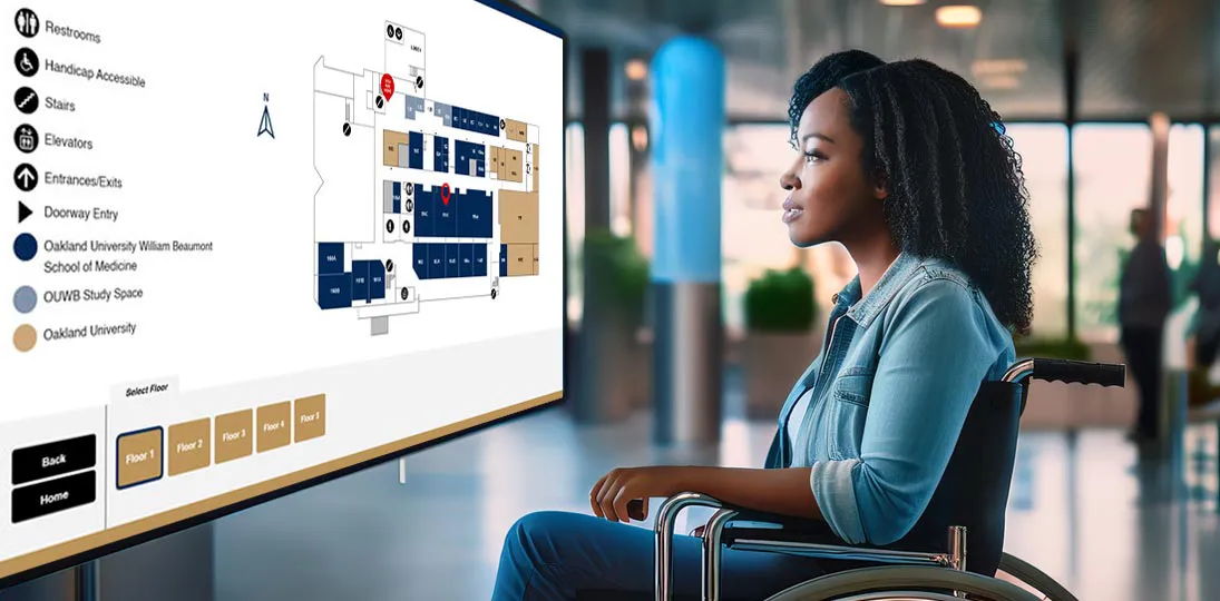 photo of woman in wheelchair looking at ADA-compliant wayfinding on a touchscreen digital sign